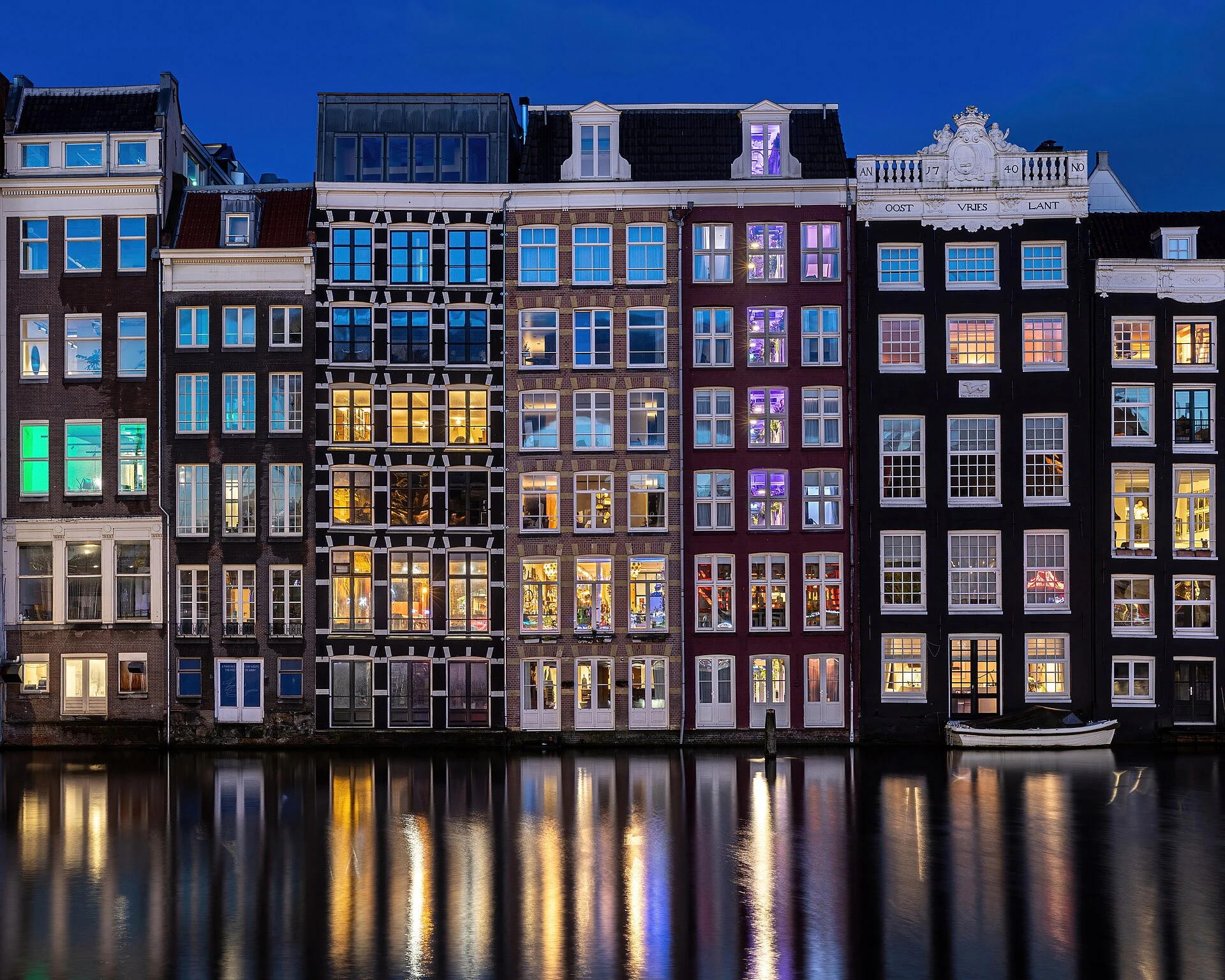 Kanalhäuser am Damrak in Amsterdam zur blauen Stunde