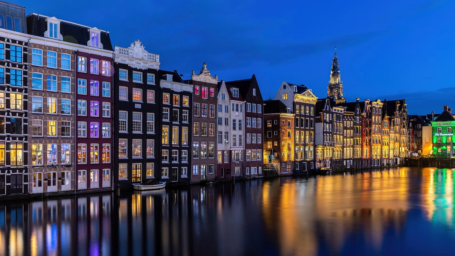 Kanalhäuser am Damrak in Amsterdam zur blauen Stunde