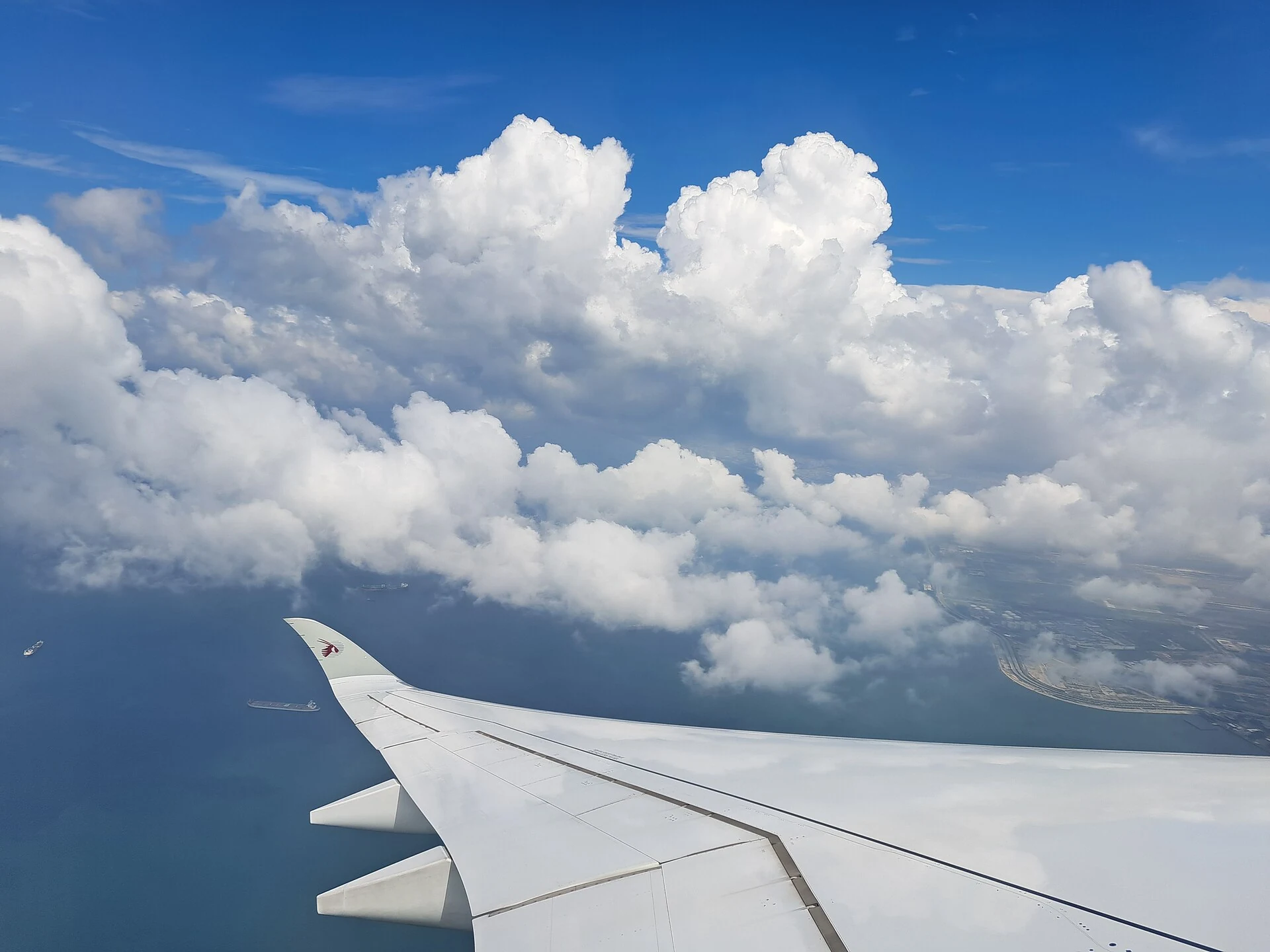 Qatar Airways aircraft wing above the clouds