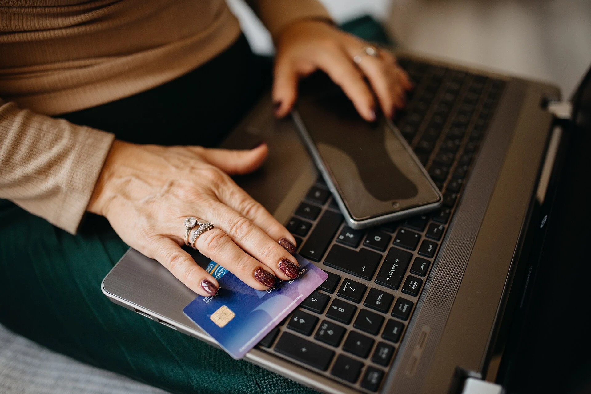 Zahlungskarte und Smartphone neben einem Computer