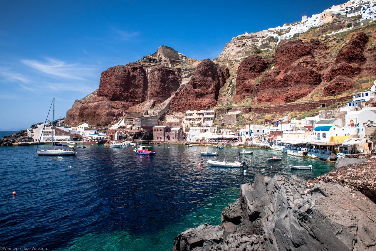 Barche e taverne nella baia di Ammoudi sotto la scogliera di Oia