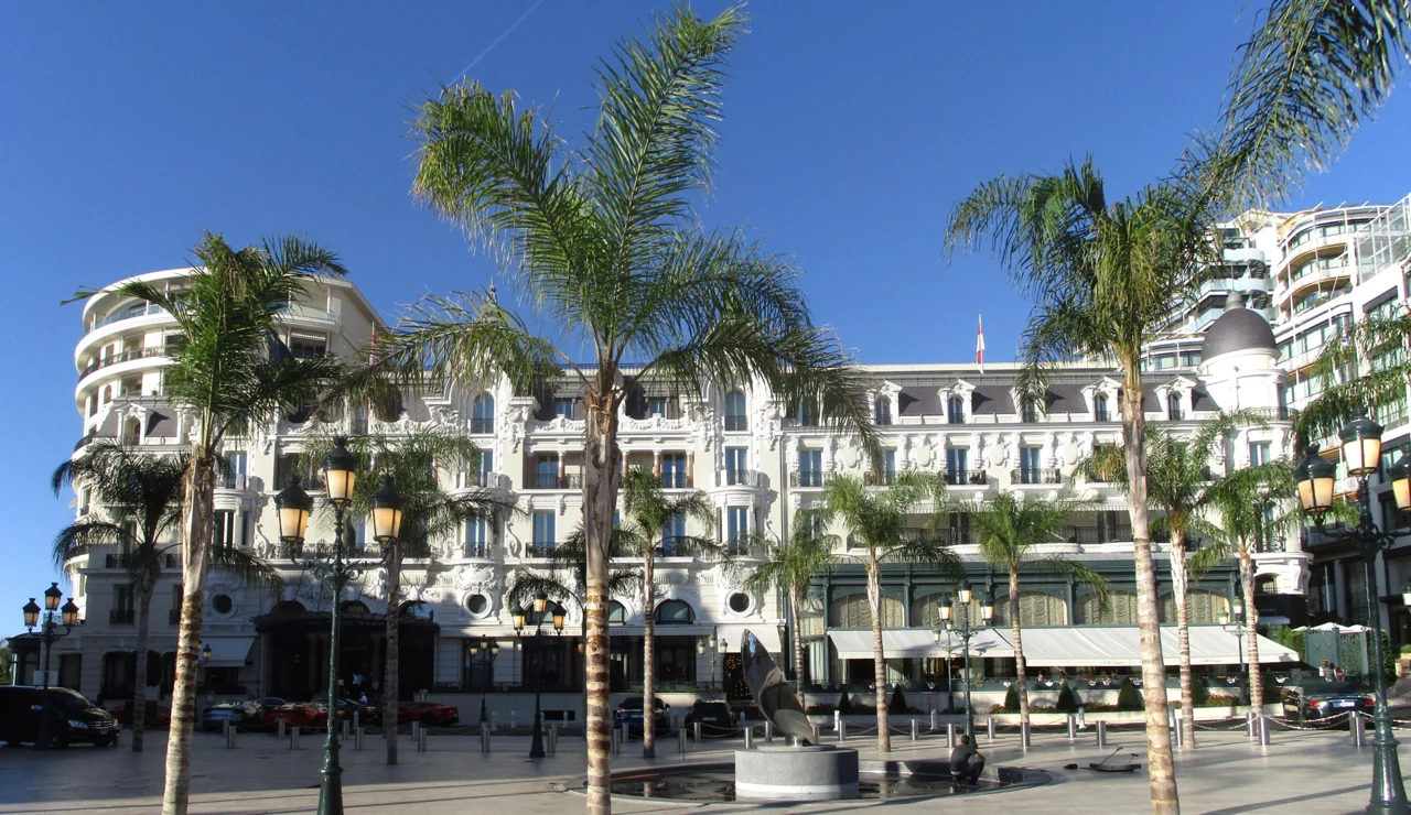 La facciata dell’Hôtel de Paris tra le palme della piazza
