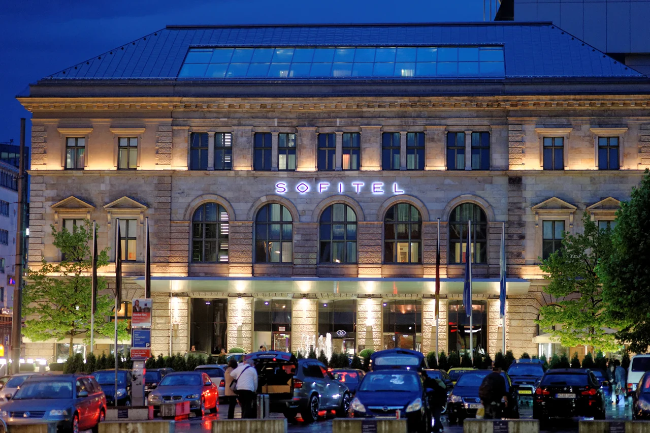 La facciata illuminata del Sofitel Munich Bayerpost al crepuscolo